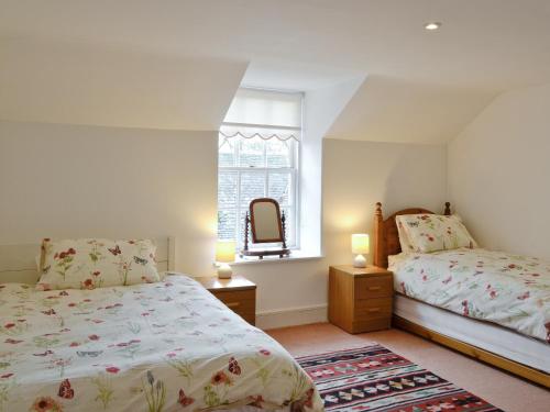 Insch的住宿－The Mews，一间卧室设有两张床和窗户。