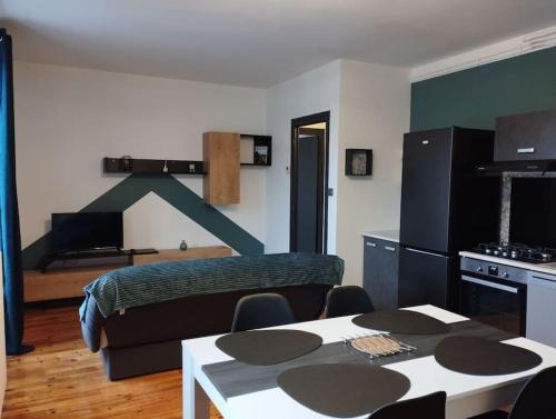 een slaapkamer met een bed en een tafel met stoelen bij Appartement moderne in Le Puy en Velay