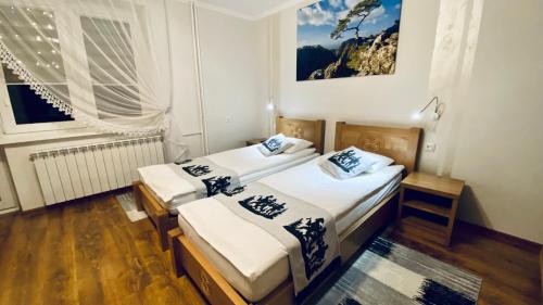 two beds in a small room with a window at Apartamenty w Maniowach in Maniowy