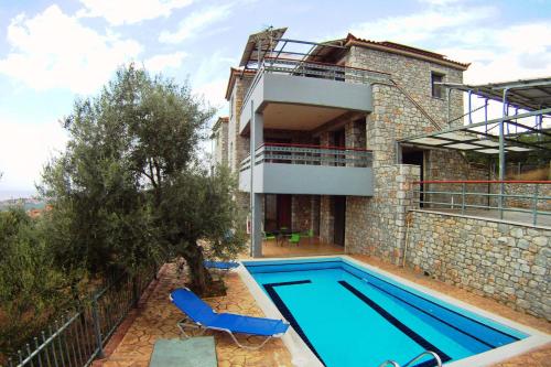 a house with a swimming pool in front of it at Βίλα Ηρώ in Riglia