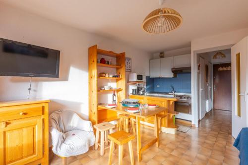 a kitchen with a table and a kitchen with a tv at Charming studio at the foot of the ice rink in Le Grand-Bornand