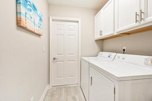 a white laundry room with a washer and dryer at Casa Del Mare at the Beach 2 bd rms W King Beds in Naples