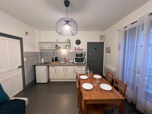 une cuisine et une salle à manger avec une table en bois dans l'établissement F2 Marx Domoy - Tout équipé D, à Clermont-Ferrand