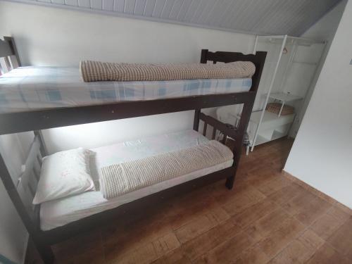 two bunk beds in a room with a wooden floor at Chalé Arizona in São Roque