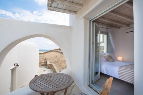 1 dormitorio con vistas a una cama y una ventana en Koumi Homes Mykonos en Ftelia