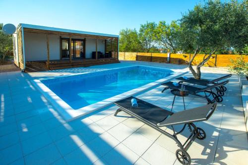 - une piscine avec une table et une maison dans l'établissement MY DALMATIA - Holiday home Relax with private pool, à Sveti Filip i Jakov