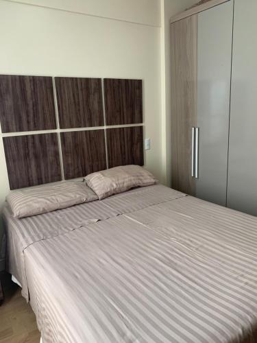 um quarto com uma cama grande e uma grande cabeceira. em Porto Marina 1 em Salvador