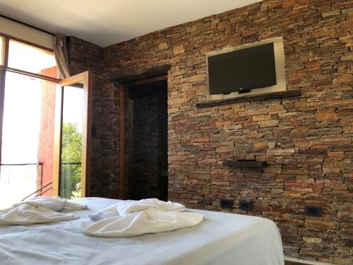 a bedroom with two white towels on a bed with a brick wall at Portal de la Cuesta in San Rafael