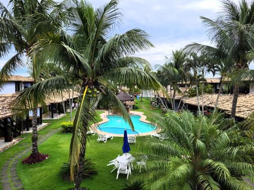 eine Luftaufnahme eines Resorts mit Pool und Palmen in der Unterkunft Maison Bardot 1 - Casa em condomínio para 4 em Geribá, Búzios in Búzios