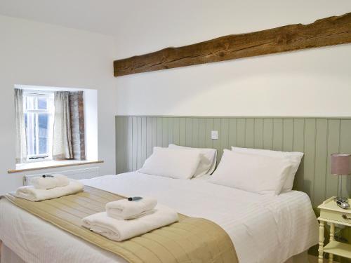 een slaapkamer met een groot wit bed en handdoeken bij Waggoners Ban in North Willingham
