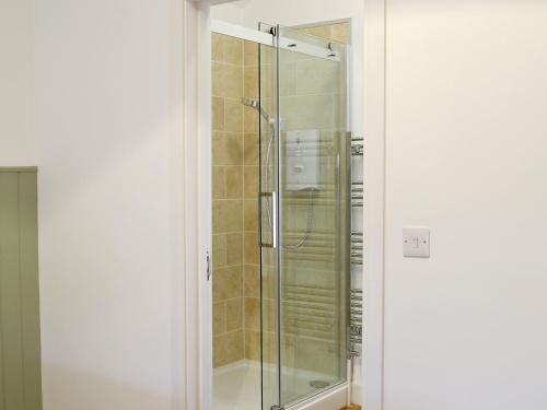 een douche met een glazen deur in de badkamer bij Waggoners Ban in North Willingham