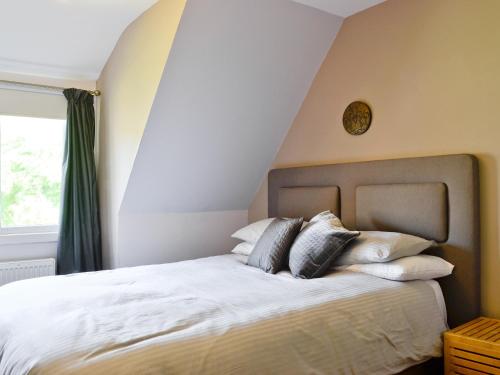 a bedroom with a bed with pillows and a clock on the wall at The Ranch in Benmore