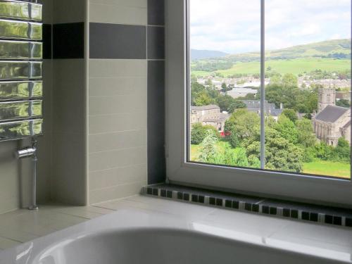 uma banheira na casa de banho com uma janela em Beech Hill em Burneside