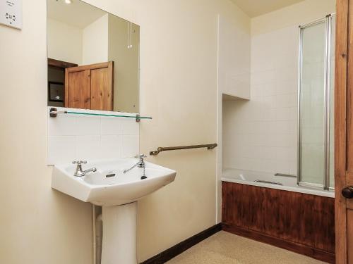 a bathroom with a sink and a bath tub at South Court Apt - FHP in Combe Martin