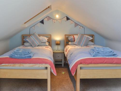 two beds in a room with a attic at Seaside Retreat in Amble