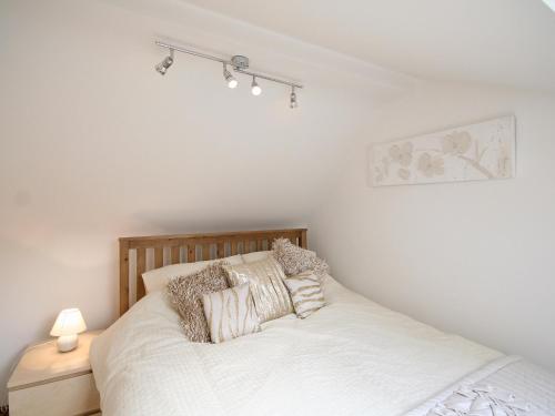 a bedroom with a bed with white sheets and pillows at Barn Cottage - E5560 in Winthorpe