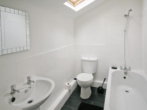 a white bathroom with a sink and a toilet and a tub at Barn Cottage - E5560 in Winthorpe