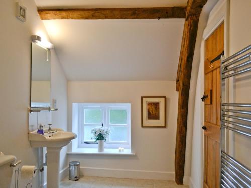 a bathroom with a sink and a window at The Grooms Cottage in Ashperton