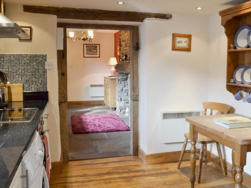 a kitchen with a door leading to a dining room at Marl Farm Cottage in Hayfield