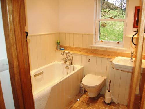 a bathroom with a tub and a toilet and a sink at Gutherscale Lodge in Portinscale
