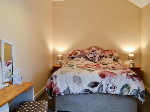 a bedroom with a bed and a desk with two lamps at Doves Den in Gooseham