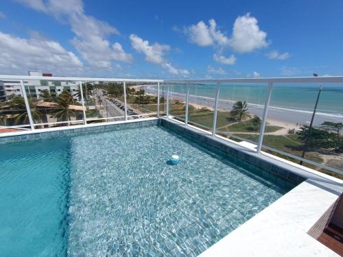 una piscina en la parte superior de un edificio con playa en Paradise Beach Flat - Pé na Areia Bessa, en João Pessoa