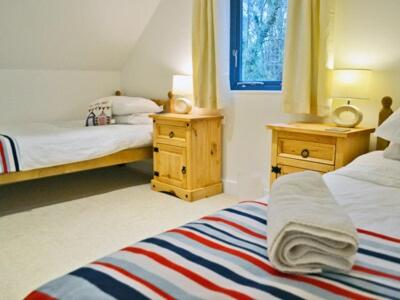 a bedroom with two beds and two night stands at Grove Lodge - 27847 in Marazion