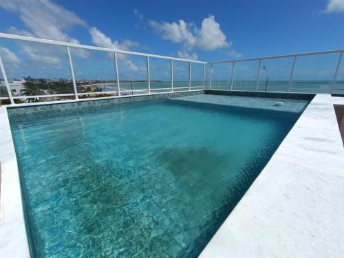 a swimming pool on the roof of a building at Paradise Beach Flat - Pé na Areia Bessa in João Pessoa