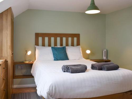 a bedroom with a large bed with two towels on it at The Coach House - Or4 in Henfynyw Upper