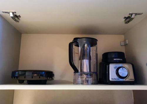 a blender and a toaster sitting on a shelf at Flat novo no Eco Resort in Tamandaré