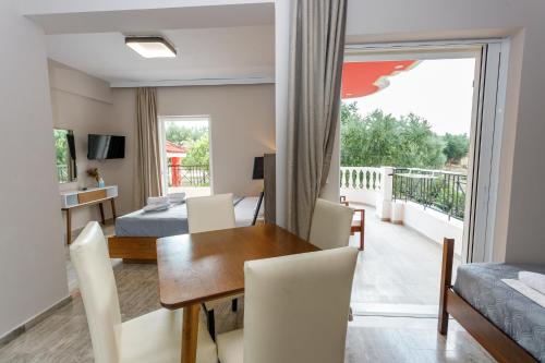 a living room with a dining room table and a balcony at Foinikounta view in Finikounta