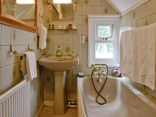 a bathroom with a sink and a bath tub at Y Bwthyn in Bala
