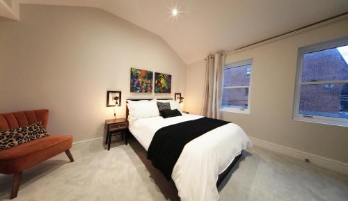 セント・オールバンズにあるRitual Stays stylish 1-Bed Flat in the Heart of St Albans City Centre with Working Space and Super Fast WiFiのベッドルーム1室(ベッド1台、椅子、窓付)