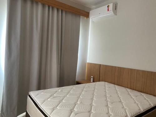 a bedroom with a white bed and a window at Condomínio Recanto do Bosque - RBF-10 in Caldas Novas