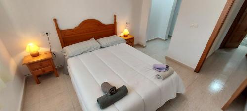 1 dormitorio con 1 cama blanca grande y 2 lámparas en Villa Bélgica en Gran Alacant, en Puerto Marino