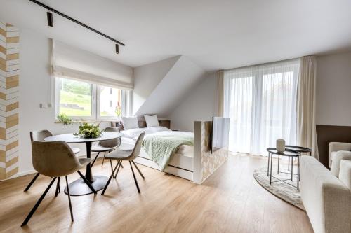sypialnia z łóżkiem, stołem i krzesłami w obiekcie Apartmány u Lesa w mieście Dolní Morava