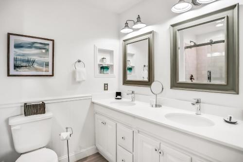 a white bathroom with two sinks and a toilet at 95100 Sandpiper in Fernandina Beach