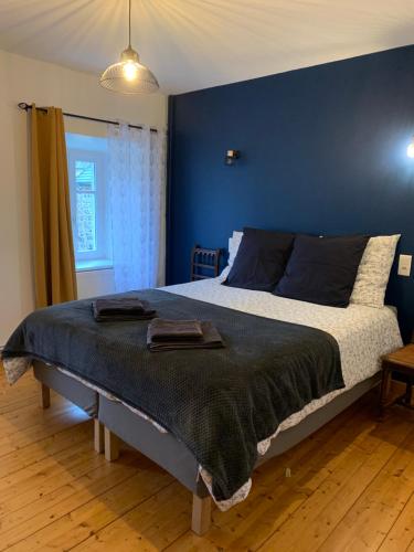 1 dormitorio con 1 cama grande y pared azul en Gîte de SAY, en Gelles