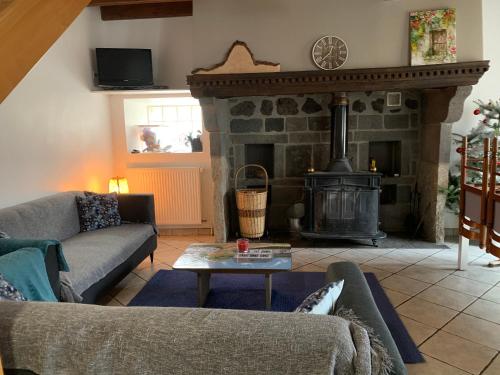 a living room with a fireplace with couches and a table at Gîte de SAY in Gelles