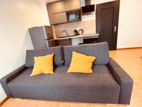 - un canapé gris avec deux oreillers jaunes dans la cuisine dans l'établissement PETiT MULHOUSE 301 - Lovely appartement - Cuisine - Wifi, à Mulhouse