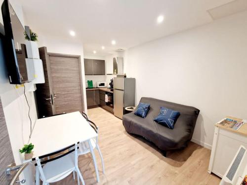 a living room with a couch and a table at Appartement Moderne Neuf F2 Centre ville in Valence