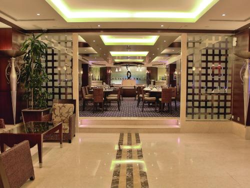 a restaurant with a dining room with tables and chairs at Raouche Arjaan by Rotana in Beirut