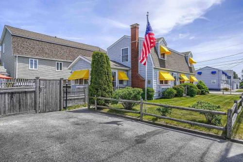 a house with a fence and an american flag at Sunshine House steps from Beach in Seabrook