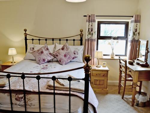 a bedroom with a bed and a desk and a window at Greystones Cottage in Hardraw