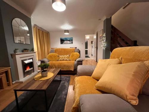 uma sala de estar com um sofá e uma lareira em Lovely Stylish 3 Bed House with Free Parking em Norwich