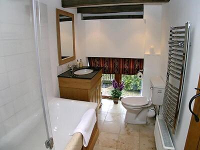 a bathroom with a tub and a toilet and a sink at Thornsdale Oast House in Stone