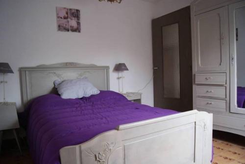 1 dormitorio con 1 cama con sábanas moradas y vestidor en Gîte de Laurelie, en Andryes