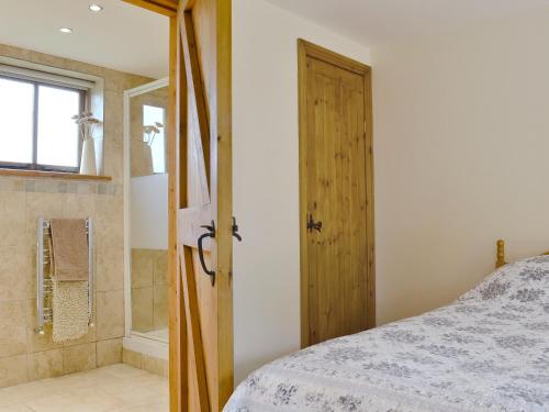 a bedroom with a bed and a glass shower at The Old Carthouse in Abbots Bromley