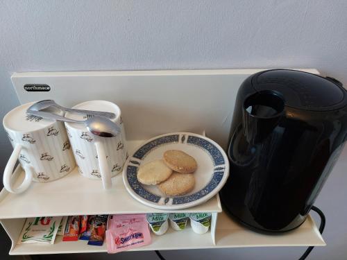 a shelf with a tea pot and a plate of food at The Norwood in Torquay
