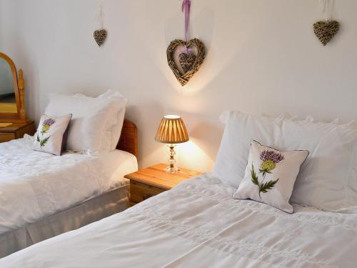 a bedroom with two beds with pillows and a heart on the wall at Addylea - 16312 in Bowland Bridge